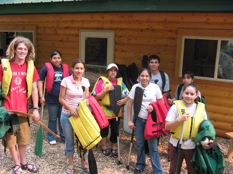 A photo of a group of campers getting ready to go canoeing.